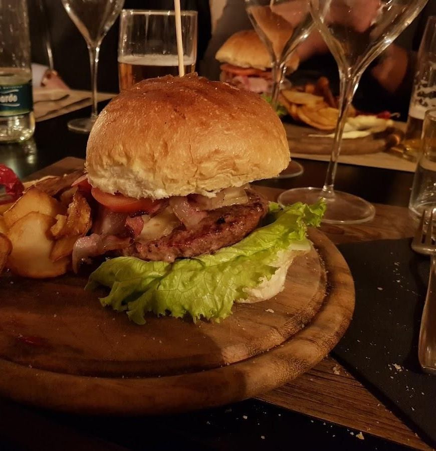 Hamburger con pancetta e patate sul tagliere di legno